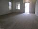 Carpeted living room bathed in natural light from front windows at 7173 Las Colinas Ave, Las Vegas, NV 89179