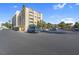 Attractive building with a large parking lot, mature trees, and well-maintained landscaping under a clear blue sky at 725 N Royal Crest Cir # 246, Las Vegas, NV 89169