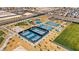 Aerial view of community tennis and pickleball courts, volleyball, playground, and open fields at 7714 Duran Harbor Ln, North Las Vegas, NV 89084