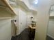 A well-lit walk in closet with shelves, a door and dark wood floors at 833 Aspen Peak Loop # 1021, Henderson, NV 89011