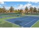 Outdoor tennis court for sports enthusiasts, surrounded by trees and greenery under a sunny sky at 8537 Glenmount Dr, Las Vegas, NV 89134