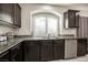 Kitchen sink and stainless steel dishwasher, featuring dark cabinets at 8543 Alpine Vineyards Ct, Las Vegas, NV 89139