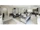 Bright open-concept living room with modern kitchen, marble floors, and elegant gray sofas at 8543 Alpine Vineyards Ct, Las Vegas, NV 89139