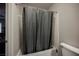 A shower-tub combination with a neutral curtain and tile surround at 8543 Alpine Vineyards Ct, Las Vegas, NV 89139