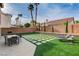 Spacious backyard with artificial grass, patio, dining set, and lounge chairs at 8636 Caribbean Ct, Las Vegas, NV 89117