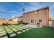 Large backyard with manicured grass, a patio with an outdoor dining set, and a grill at 8636 Caribbean Ct, Las Vegas, NV 89117