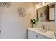 Bright powder bathroom with white vanity, stylish fixtures, and decorative starburst accents at 8636 Caribbean Ct, Las Vegas, NV 89117