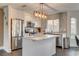 Contemporary kitchen with white cabinetry, a stainless steel fridge, and a center island with marble countertop at 8636 Caribbean Ct, Las Vegas, NV 89117