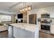 Open concept kitchen with white cabinetry, stainless steel appliances, and a center island adjacent to the living room at 8636 Caribbean Ct, Las Vegas, NV 89117