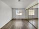 Empty bedroom with a closet with mirrored sliding doors, hard floors, and natural light at 913 Boulder Springs Dr # 202, Las Vegas, NV 89128