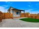 A covered porch with natural wood floors and gravel landscaping complements a yard of green artificial turf at 974 Balzar Ave, Las Vegas, NV 89106