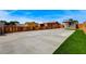 Wide backyard with long driveway, surrounded by a wooden fence, and accented with artificial grass at 974 Balzar Ave, Las Vegas, NV 89106