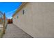 Exterior side view of the house and gravel-covered backyard featuring a chain link fence at 974 Balzar Ave, Las Vegas, NV 89106