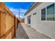 Side view of the house and fenced backyard, showing a gravel ground cover and a sliding glass door entrance at 974 Balzar Ave, Las Vegas, NV 89106