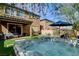 Landscaped backyard featuring a modern hot tub, artificial turf, and patio seating area at 9921 Rams Leap Ave, Las Vegas, NV 89166