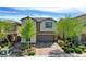 Beautiful two-story home featuring a two-car garage, brick driveway, and meticulously landscaped front yard at 9921 Rams Leap Ave, Las Vegas, NV 89166