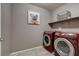 Functional laundry room equipped with front-load washer and dryer, and shelving for storage at 9921 Rams Leap Ave, Las Vegas, NV 89166