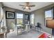 Home office with grey walls, carpet flooring, glass desk, and natural light from two windows at 9921 Rams Leap Ave, Las Vegas, NV 89166