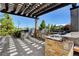An outdoor kitchen with stainless steel grills, sink, and stone counter at 9921 Rams Leap Ave, Las Vegas, NV 89166