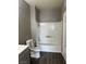 Bathroom features a shower-tub combo, gray vanity, and gray walls with dark wood floors at , Las Vegas, NV 89148