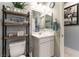 Compact bathroom with vanity, toilet, and decorative shelving at 10372 Thurso Ave, Las Vegas, NV 89166