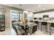 Bright dining area adjacent to the kitchen, featuring a modern glass table and access to an outdoor patio at 10372 Thurso Ave, Las Vegas, NV 89166