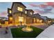Charming home with stone accents, manicured lawn, and inviting facade at dusk, showing a well-lit driveway at 10372 Thurso Ave, Las Vegas, NV 89166