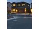 A well-maintained two-story home with dark stucco and stone accents, manicured yard and lighting at 10372 Thurso Ave, Las Vegas, NV 89166