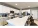 Bright kitchen features white cabinetry, stainless steel appliances, a spacious island with seating, and a modern design at 10372 Thurso Ave, Las Vegas, NV 89166