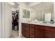 Bathroom featuring double sinks with white countertops and a view into the walk-in closet at 105 Pollentia Ave, North Las Vegas, NV 89084
