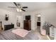 Bright bedroom with a ceiling fan, TV, and open doorways to the bathroom and office at 105 Pollentia Ave, North Las Vegas, NV 89084