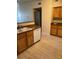 Kitchen with wood cabinets, tile countertops, a stainless steel sink and new floors at 10550 W Alexander Rd # 2183, Las Vegas, NV 89129