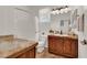 Bright bathroom features a wood vanity with a marble countertop and tub-shower combination at 10581 Santo Marco Ct, Las Vegas, NV 89135