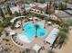 Aerial view showcasing a pool area surrounded by tall palms, tennis courts, and lounge seating at 10581 Santo Marco Ct, Las Vegas, NV 89135