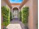 Charming front entrance featuring a pathway lined with symmetrical greenery and double doors at 10581 Santo Marco Ct, Las Vegas, NV 89135