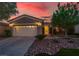 Inviting single-story home showcasing a tidy front yard and a convenient two-car garage at sunset at 10581 Santo Marco Ct, Las Vegas, NV 89135