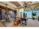 A living room with a large bookcase, fireplace, ladder, chandelier, area rug and large arched windows with nice outdoor view at 10581 Santo Marco Ct, Las Vegas, NV 89135
