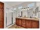 Elegant main bathroom with double vanity, framed shower, and warm wooden cabinets at 10581 Santo Marco Ct, Las Vegas, NV 89135