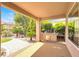 Covered patio with built-in grill, lush landscaping, and inviting space at 10581 Santo Marco Ct, Las Vegas, NV 89135