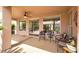 Covered patio with outdoor seating, ceiling fan, and views of the beautifully landscaped yard at 10581 Santo Marco Ct, Las Vegas, NV 89135