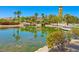 A pond reflecting a clock tower, community building, palm trees, vegetation, and blue skies at 10581 Santo Marco Ct, Las Vegas, NV 89135