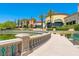 A pond with a water fountain and a community building, palm trees, and blue skies in the background at 10581 Santo Marco Ct, Las Vegas, NV 89135