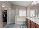 Elegant bathroom featuring a soaking tub, glass-enclosed shower, and dual vanity sinks for added convenience at 10624 Tuckermans Ave, Las Vegas, NV 89129