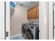 Well-equipped laundry room with upper cabinets and modern appliances at 10624 Tuckermans Ave, Las Vegas, NV 89129