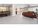 Open-concept living space with gray wood-look floors, a dining area and leather sofas for entertaining at 10624 Tuckermans Ave, Las Vegas, NV 89129