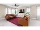 Open concept living area featuring dual leather sofas, large-screen TV, and inviting decor and windows at 10624 Tuckermans Ave, Las Vegas, NV 89129