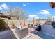 Serene backyard patio with comfortable wicker seating, potted plants, and a stylish outdoor rug, ideal for relaxation at 10624 Tuckermans Ave, Las Vegas, NV 89129