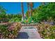 Charming backyard oasis featuring mature trees, landscaping, sitting area and brick pathways at 11037 Clarion Ln, Las Vegas, NV 89134