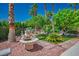 Landscaped backyard featuring a water fountain, mature trees and lush green plants at 11037 Clarion Ln, Las Vegas, NV 89134