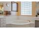 Inviting bathroom featuring a soaking tub, decorative glass block window, and updated fixtures, providing relaxation at 11037 Clarion Ln, Las Vegas, NV 89134